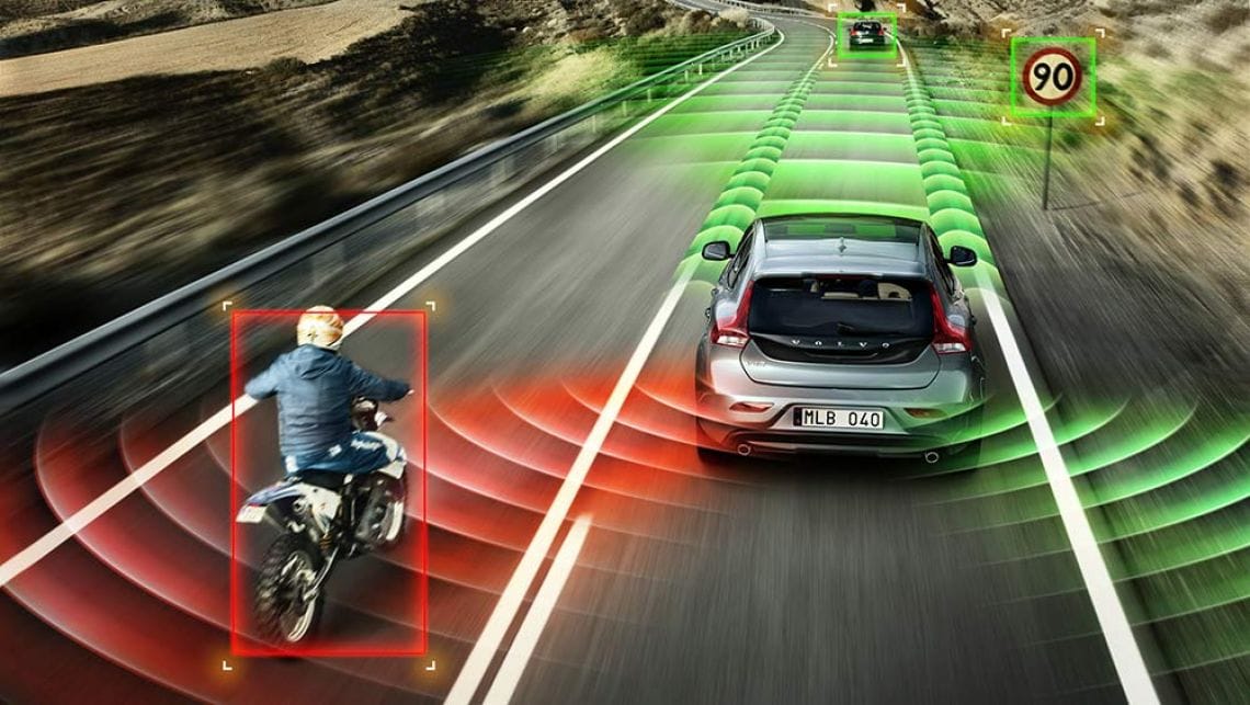 Person on motorcycle riding to the left of a car